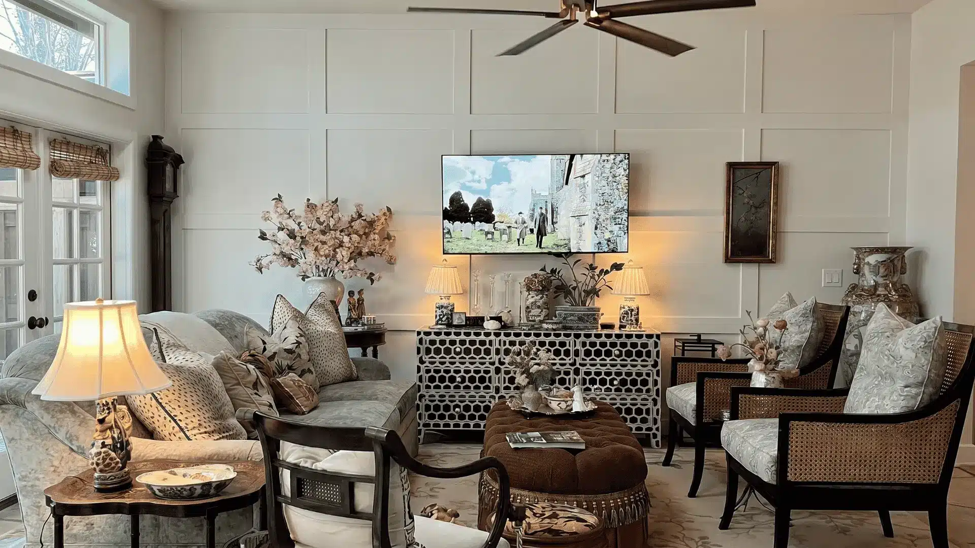 Cozy living room with layered textures, patterned furniture, wall paneling, ceiling fan, and warm lighting creating a comfortable seating area