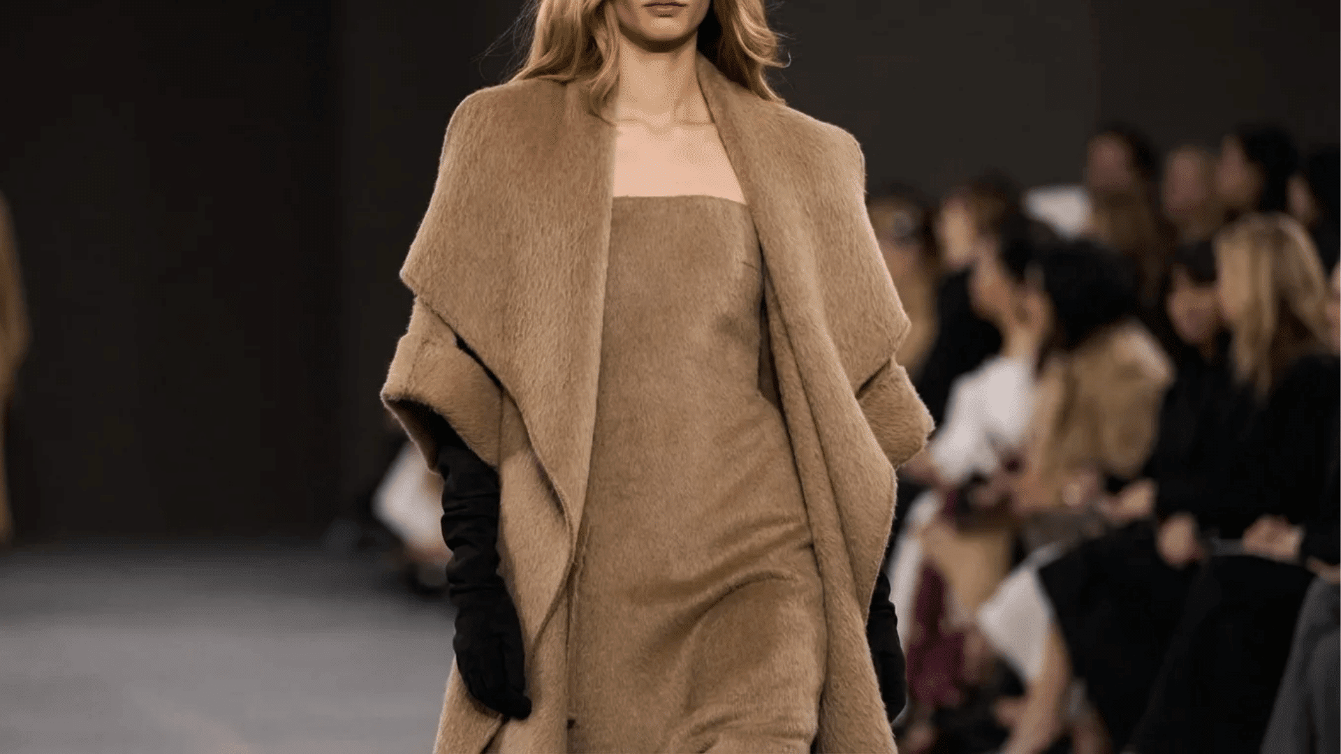 Model walking the runway in a textured brown strapless dress with a matching draped coat and black gloves (1)