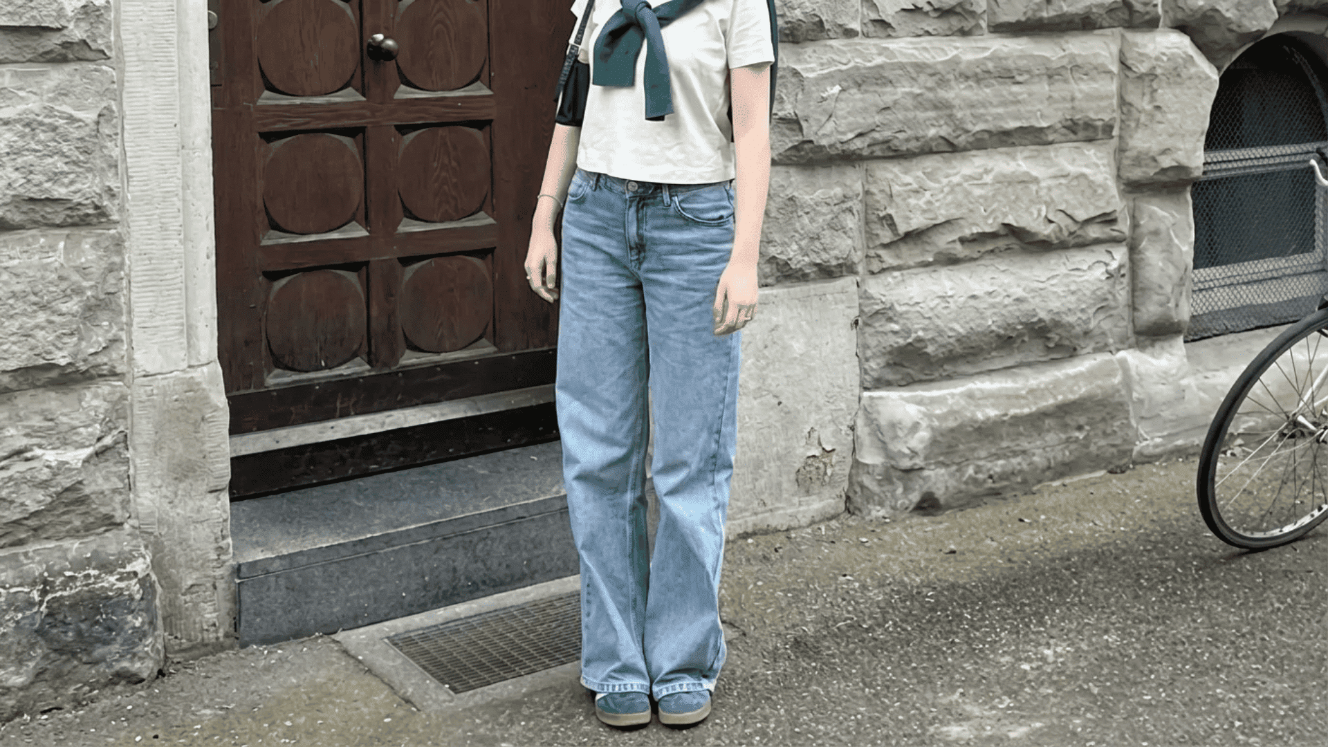 Person wearing white top, blue jeans, and green shoes with matching sweater accent, demonstrating a 3 color outfit rule