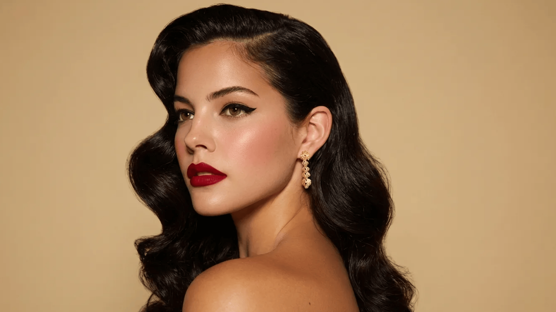 Hollywood glam blowout with deep side part, smooth sculpted waves, and a sleek, glossy finish