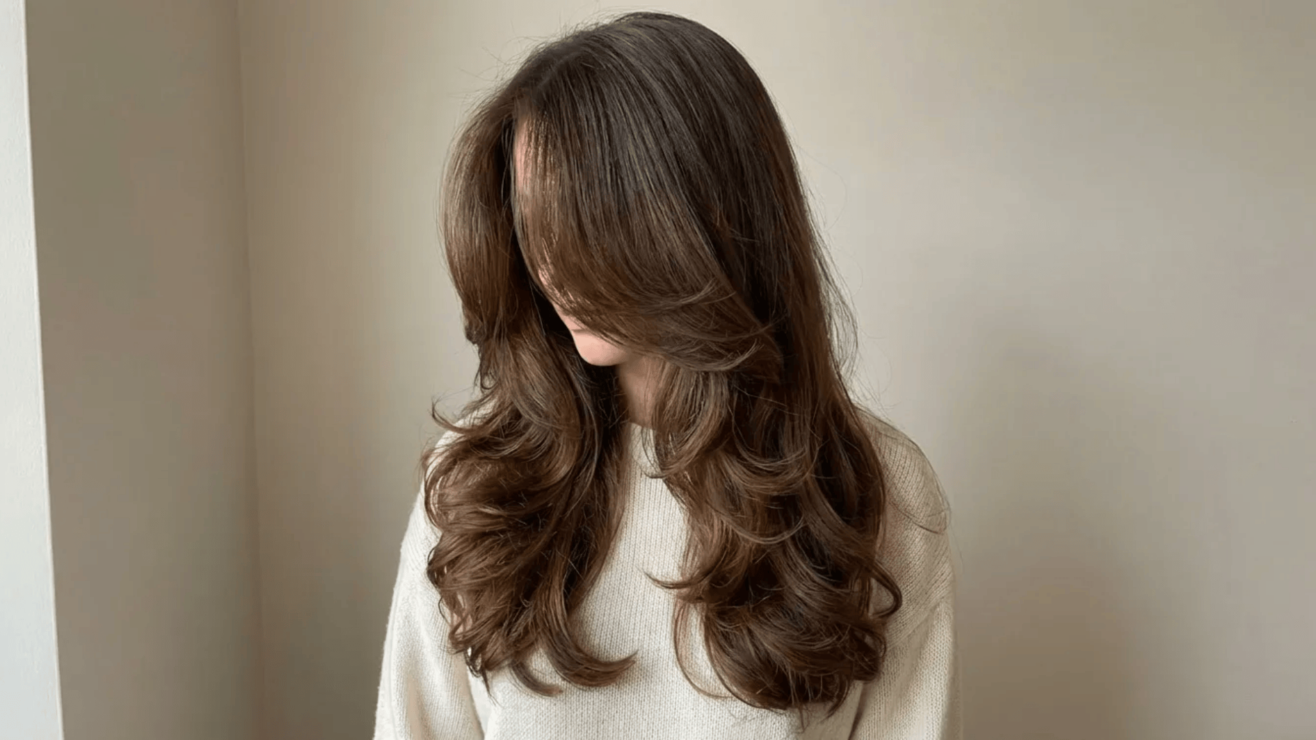 Long layered blowout with soft curls, face-framing volume, and smooth flow for a natural, full-bodied finish