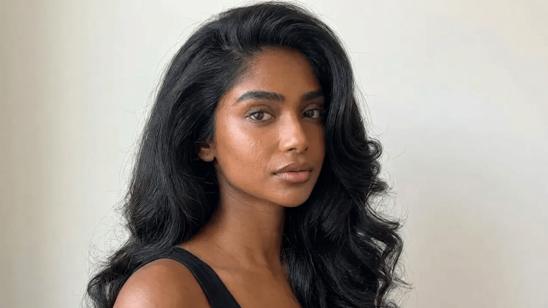 Long voluminous blowout with soft waves and a deep side part, styled for smooth shine and natural movement