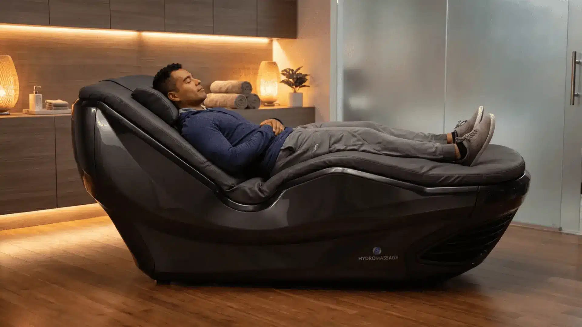 Person relaxing on a lounge chair during a hydromassage session with soft lighting