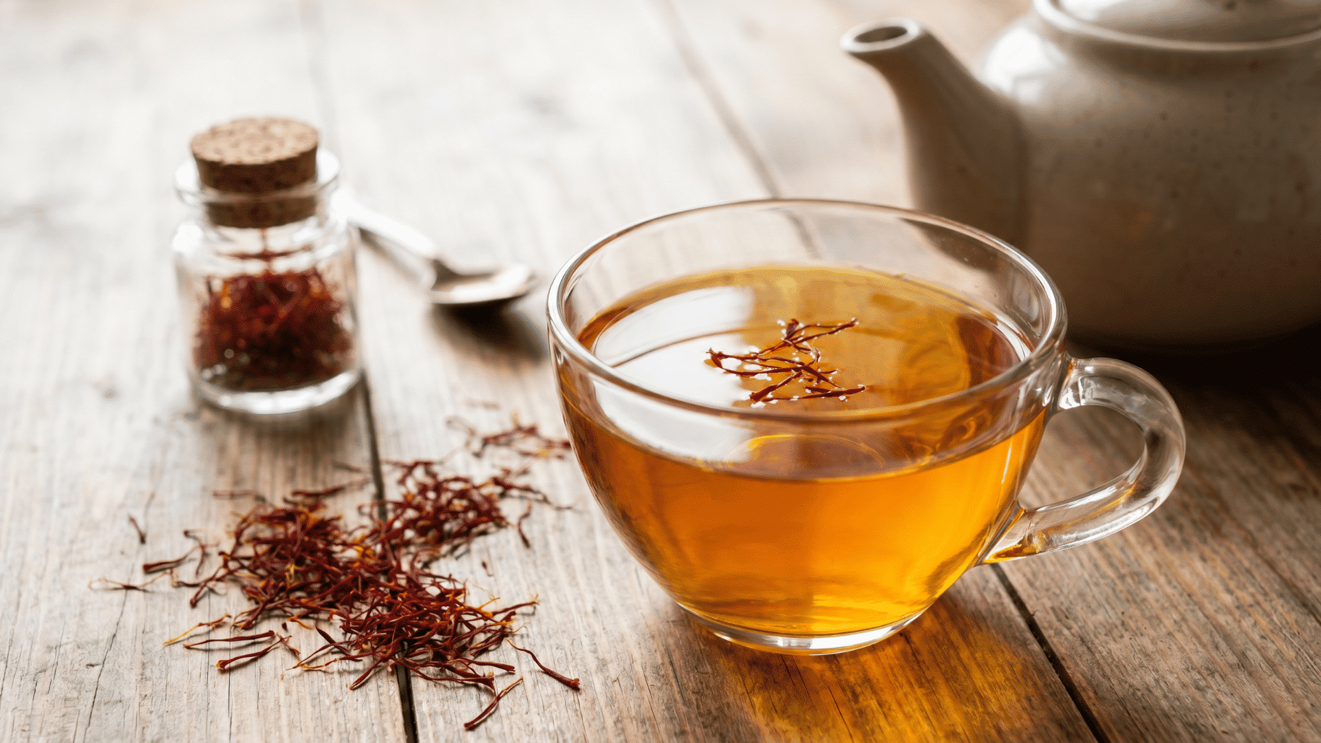 glass cup of saffron tea with saffron threads on a wooden table
