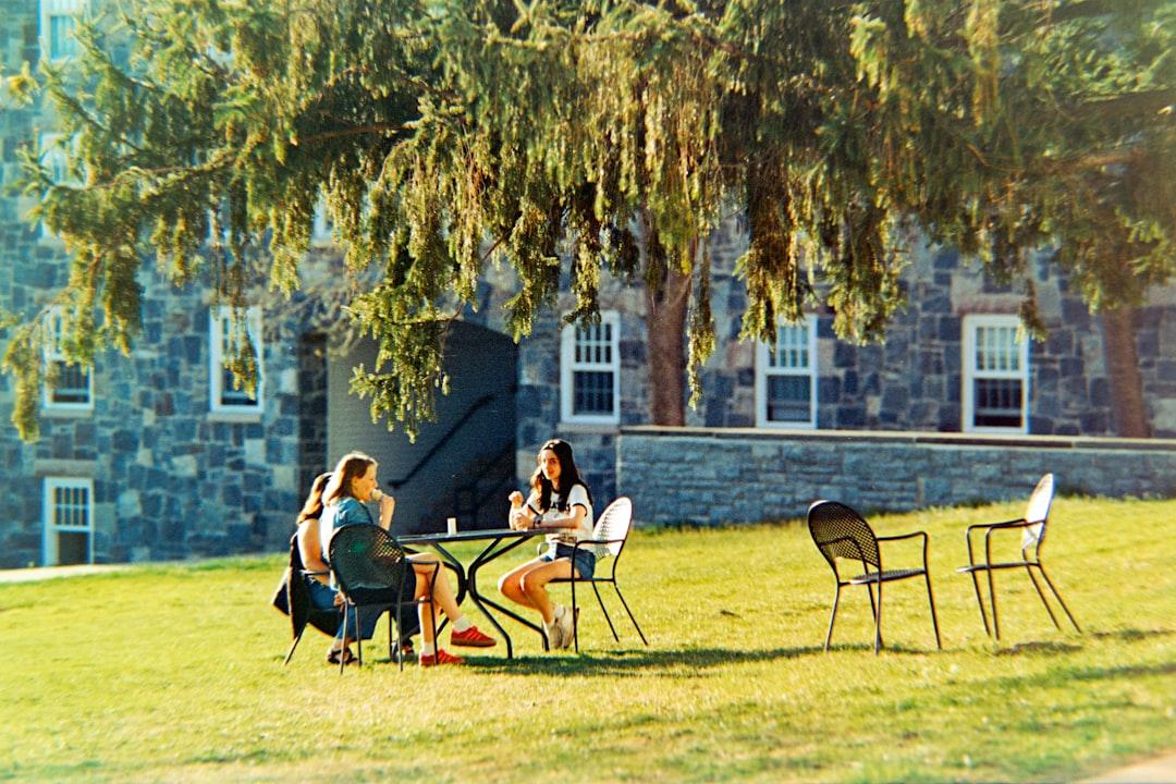 Group of college women in coordinated pastel summer dresses on a campus lawn