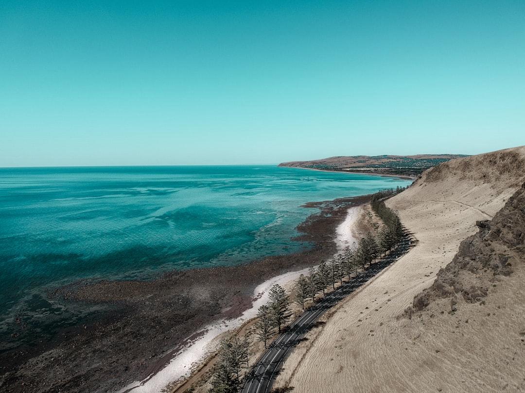 A car driving along a scenic coastal highway with ocean views in Australia