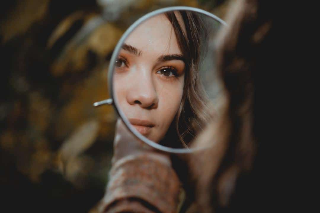 A woman looking thoughtfully in a mirror