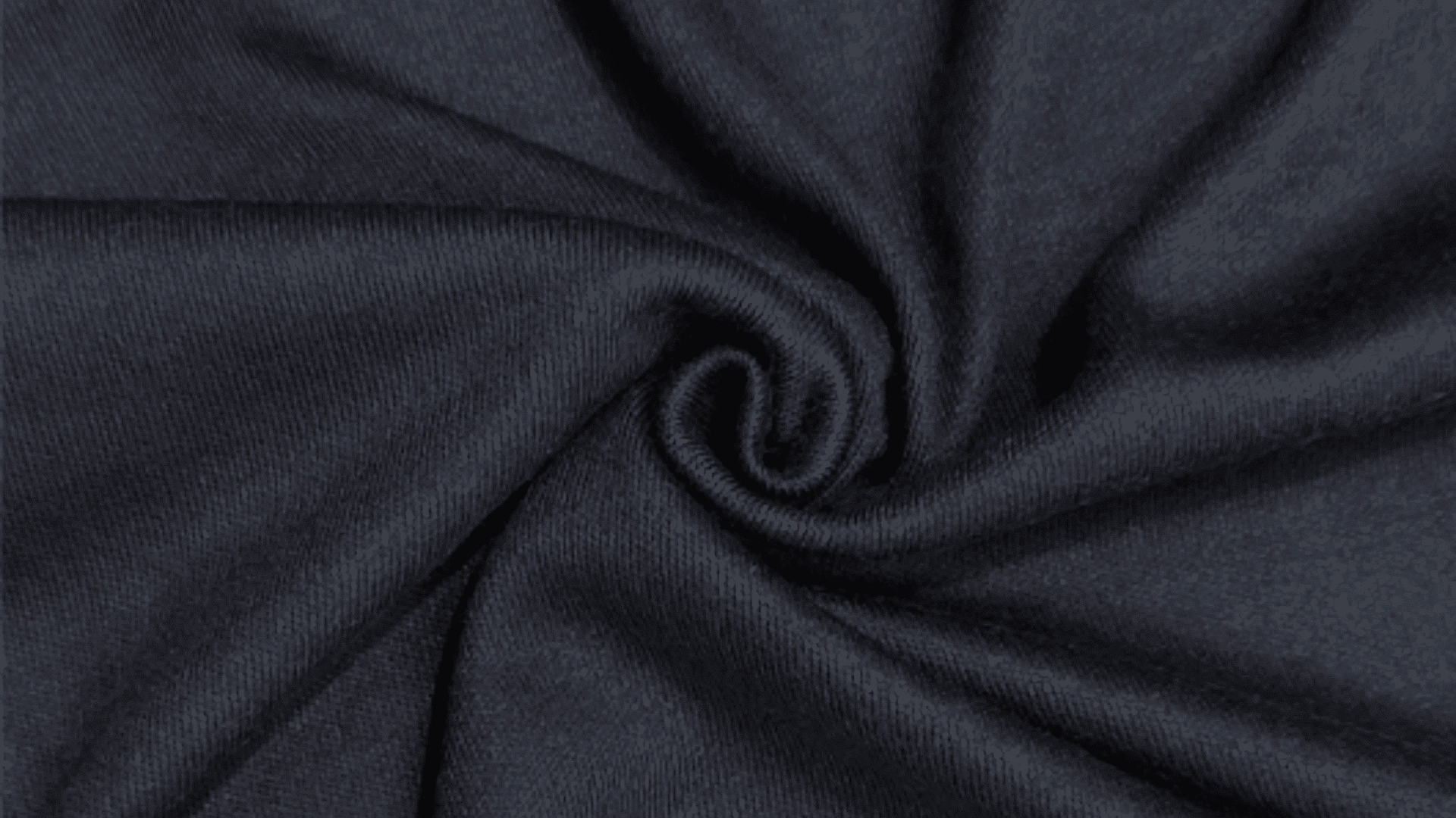 Dark textured fabric with a spiral fold pattern in the center, showing smooth knit surface.