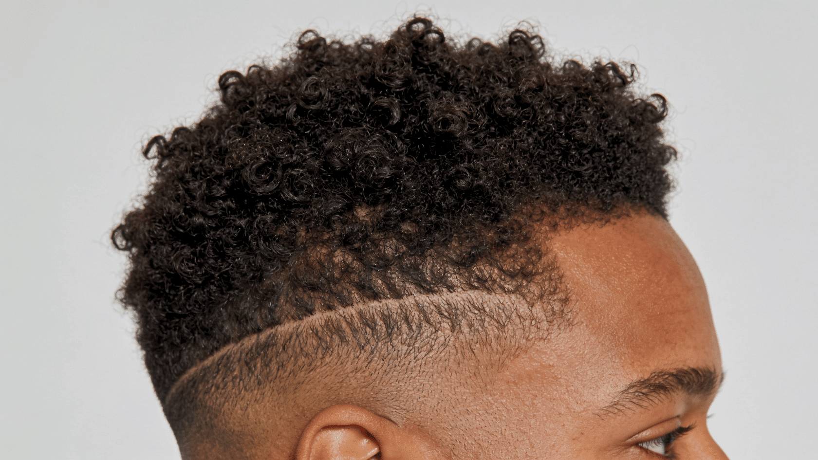 Close-up of skin mid fade with tight coiled hair and visible curl shrinkage on scalp