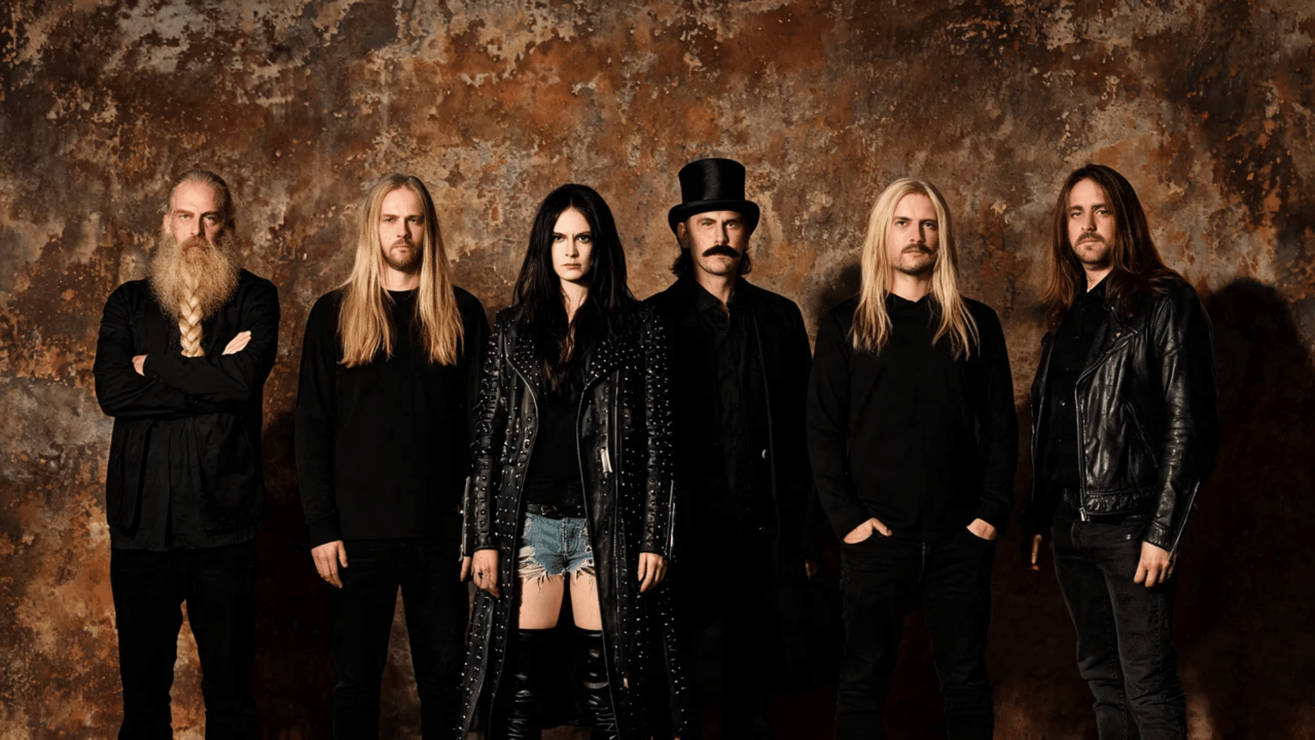 Goth music band members wearing black outfits with dark styling in a moody artistic setting.