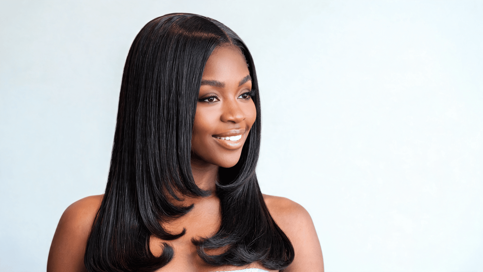 Woman wearing a straight sew-in with sleek lengths and outward-flipped ends
