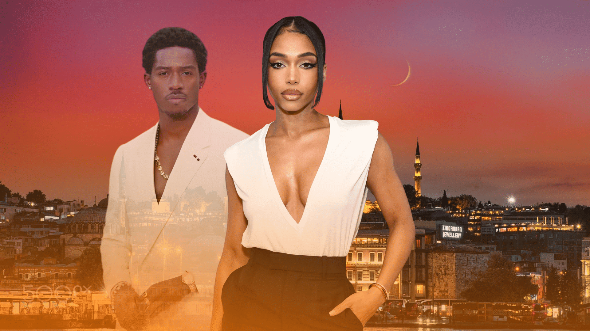 Two people standing in front of a city skyline at sunset with a woman in a white top and black pants in front.
