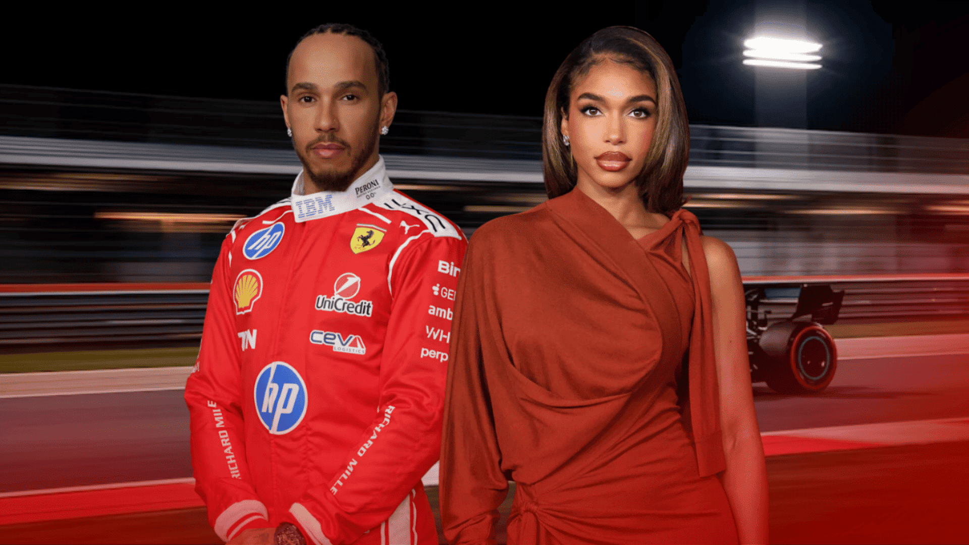 Two people standing in front of a racing track background, with one person wearing a red racing suit.