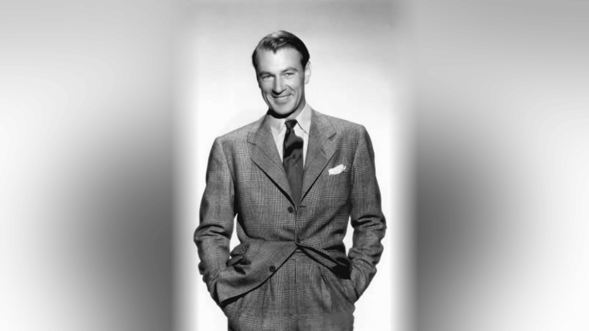 Man in a checked suit with a dark tie and pocket square, a classic tailored old Hollywood outfit for men
