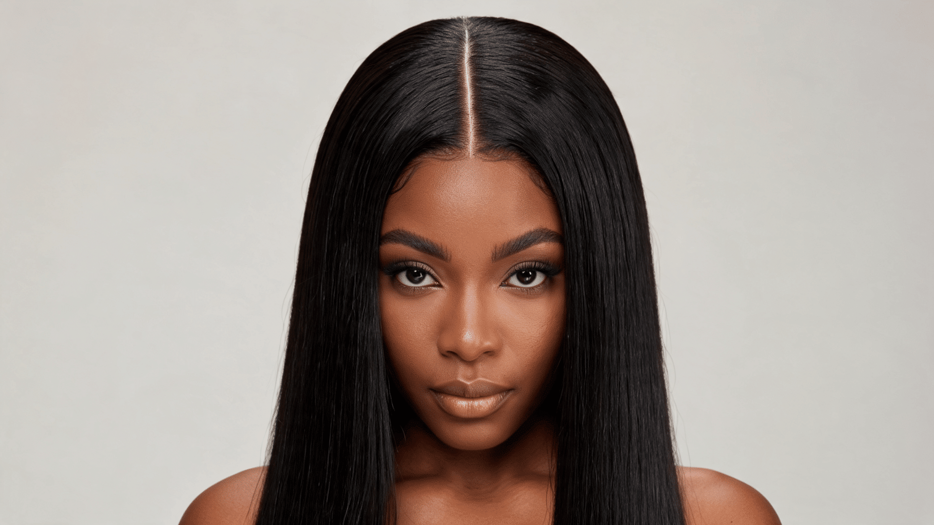 Woman wearing a bone-straight middle-part sew-in with sleek, evenly styled hair