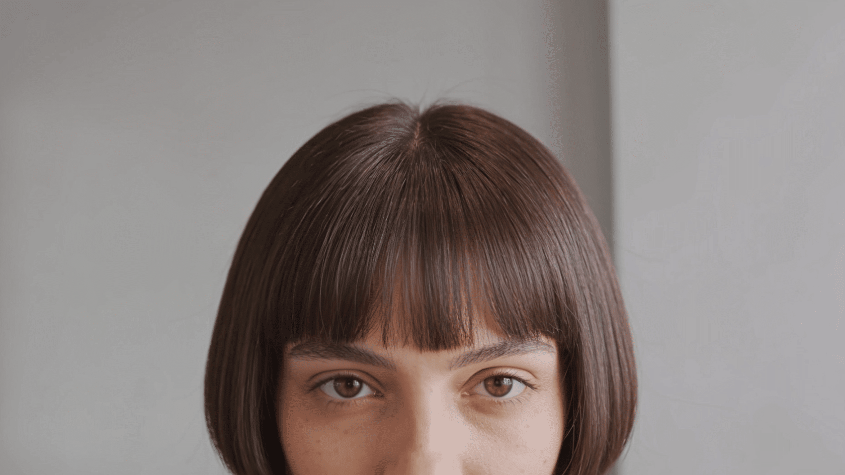 Jaw-length blunt bob haircut with straight ends and a soft fringe shown from the front