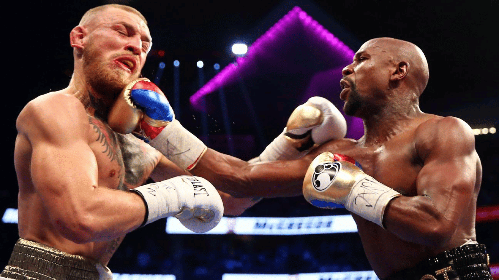 Boxing match with Floyd Mayweather landing a punch on Conor McGregor in the ring under arena lights