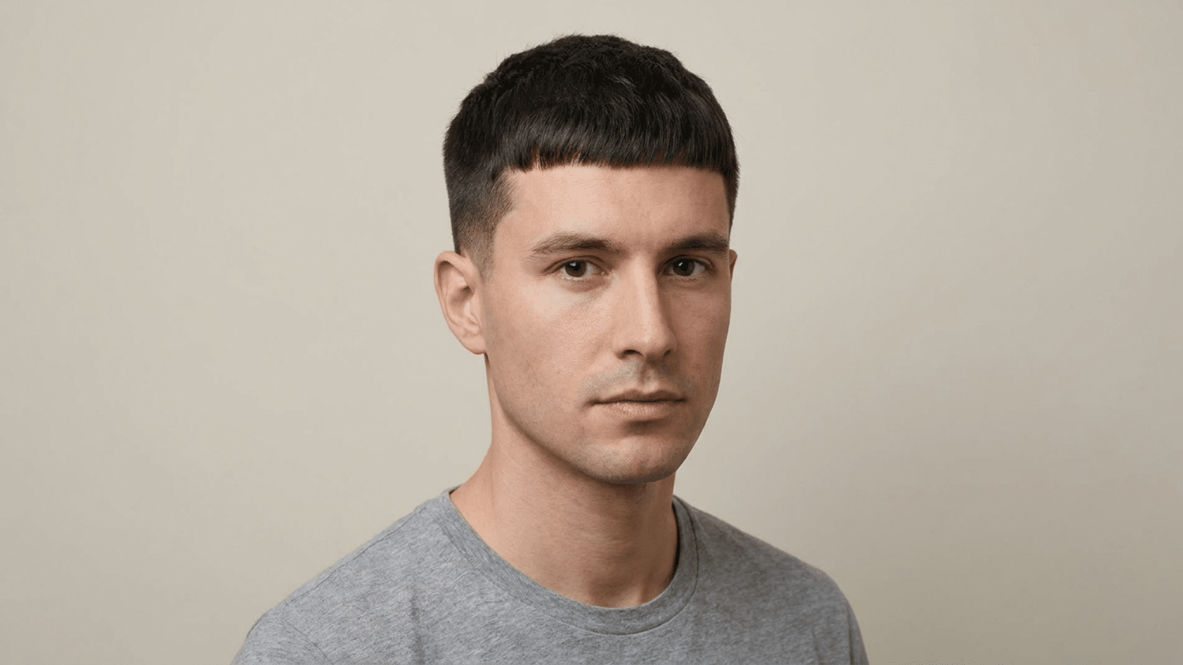 Caesar cut hairstyle for men with thinning hair showing forward-brushed fringe above the brow with tapered sides, front view.