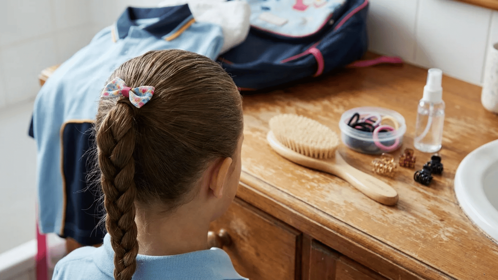 Child’s styled hair with brush and hair accessories on a counter.