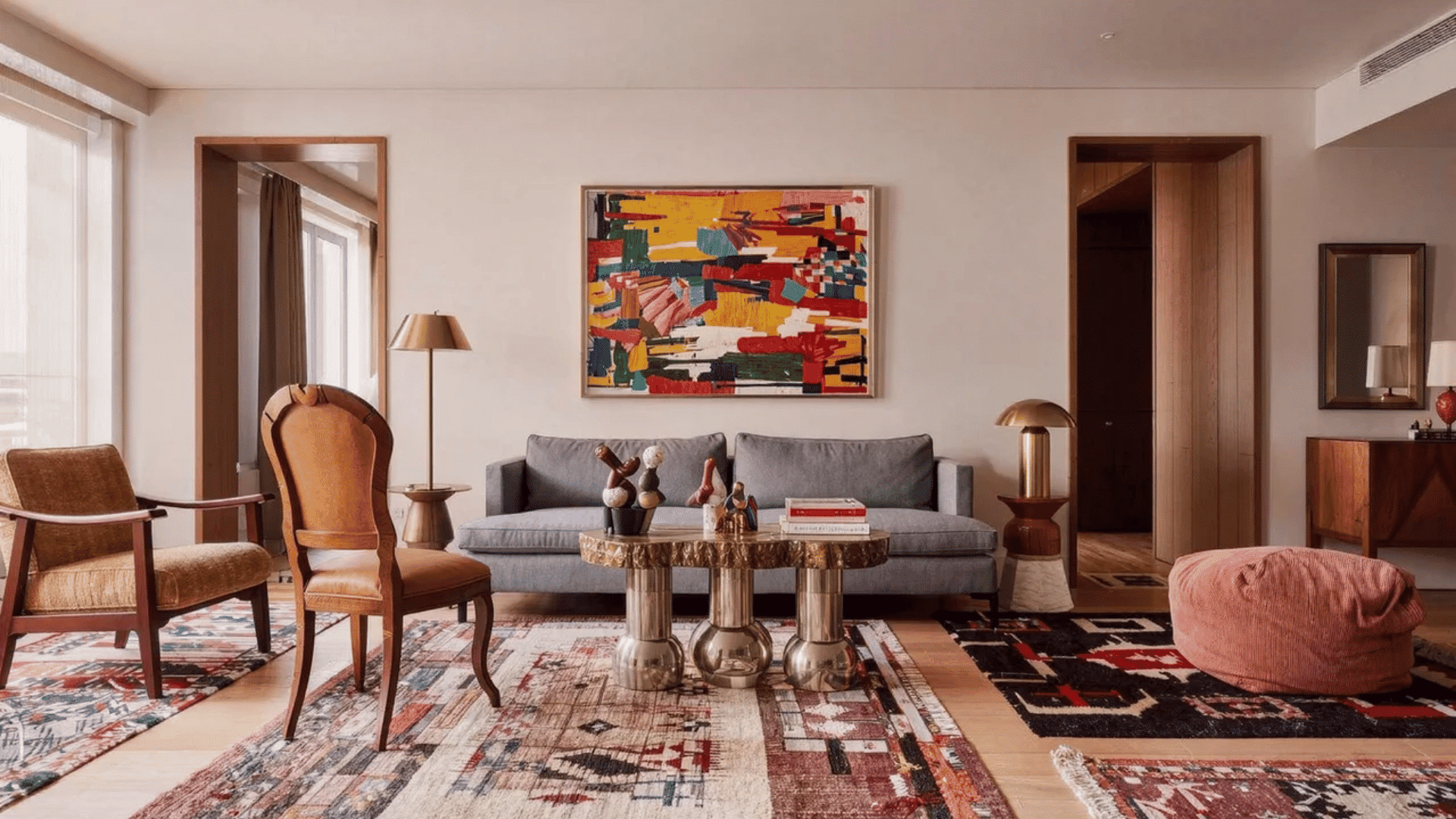 Eclectic design style featuring a modern living room with mixed furniture, abstract wall art, layered rugs, and unique decor.