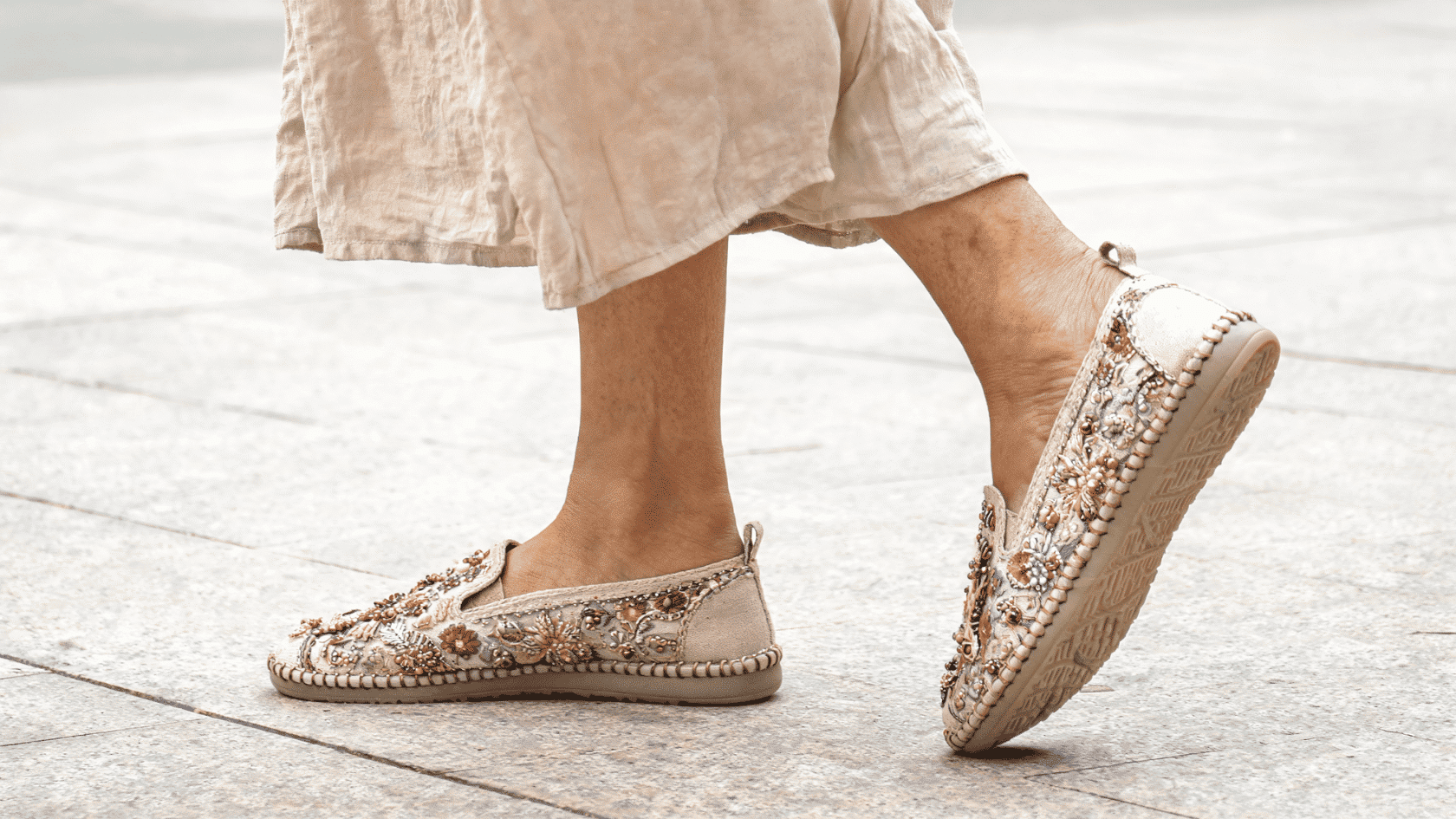 Embellished boho flats with decorative details on a woman’s feet