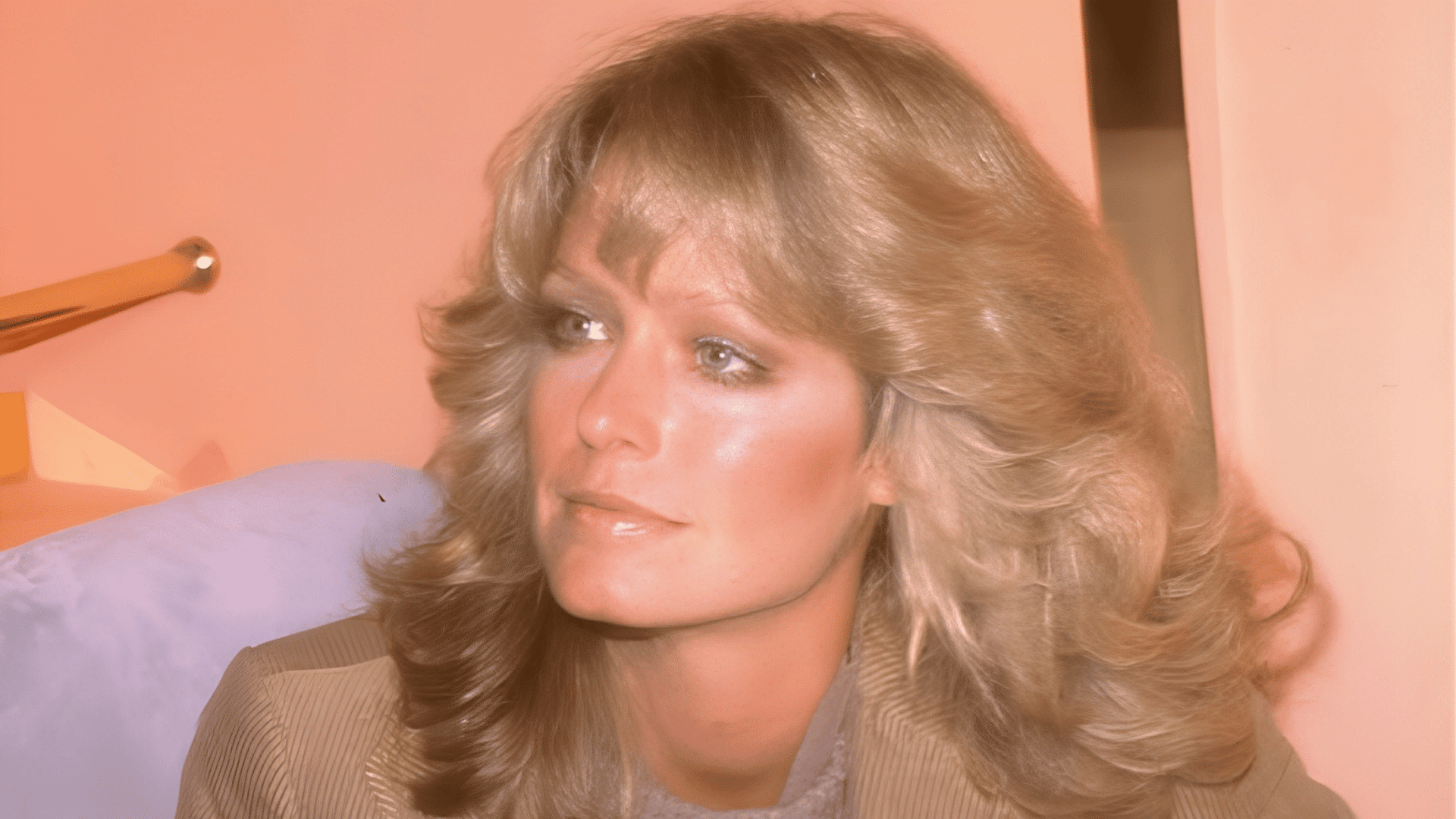 Farrah Fawcett with a long layers and bouncy curls haircut on a heart-shaped face.