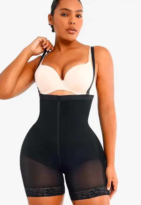 Woman wearing black high-waisted shapewear shorts with lace trim in studio setting
