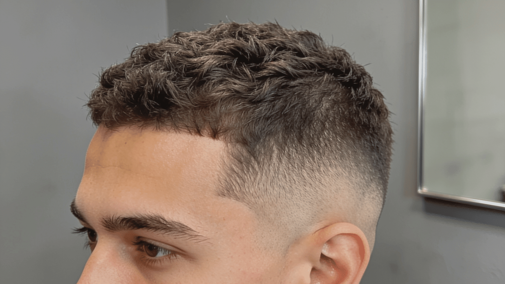 High fade haircut with closely faded sides above the temples and a short textured top