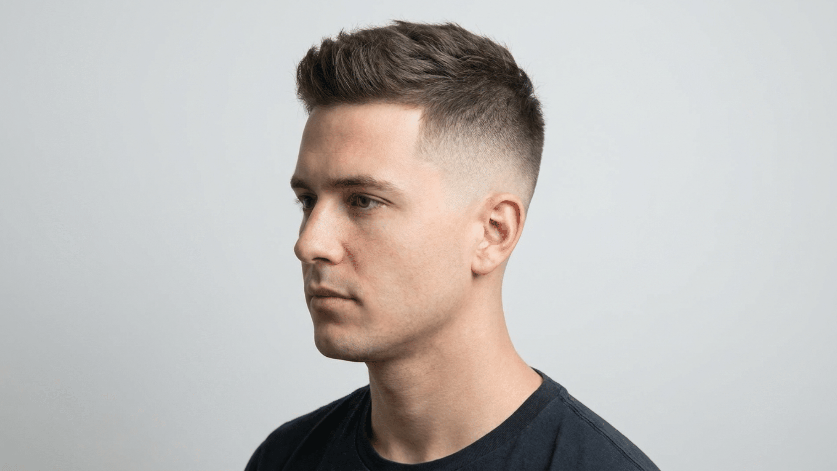 High skin fade, a hairstyle for men with thinning hair, temples tapered to skin, longer length on top, three-quarter view.
