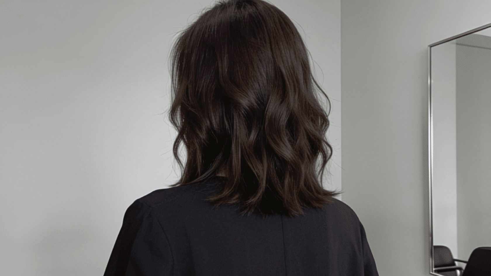 Collarbone-length lob haircut with loose waves adding volume around the sides.