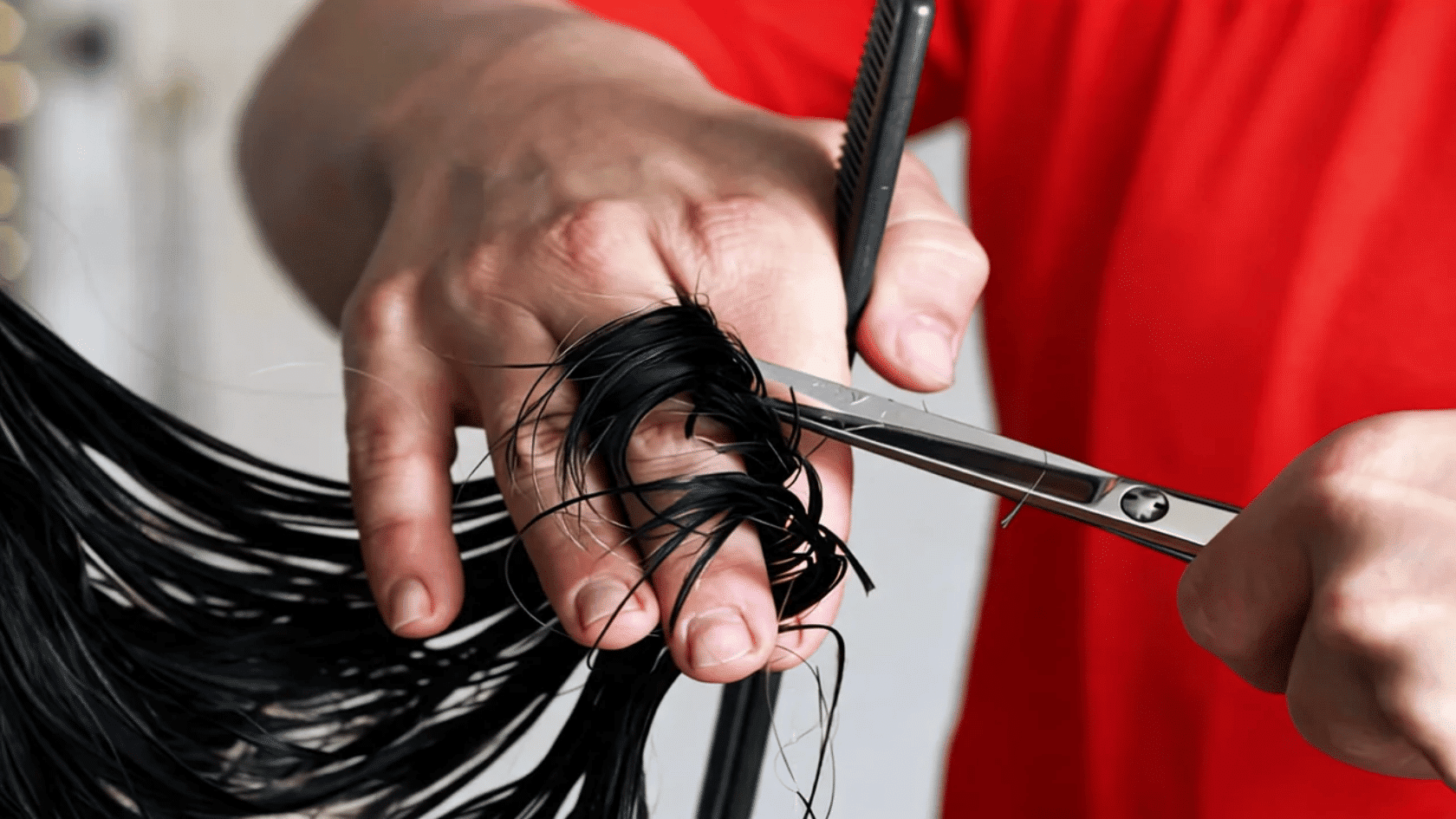 Long hair ends being trimmed with scissors to remove split ends.