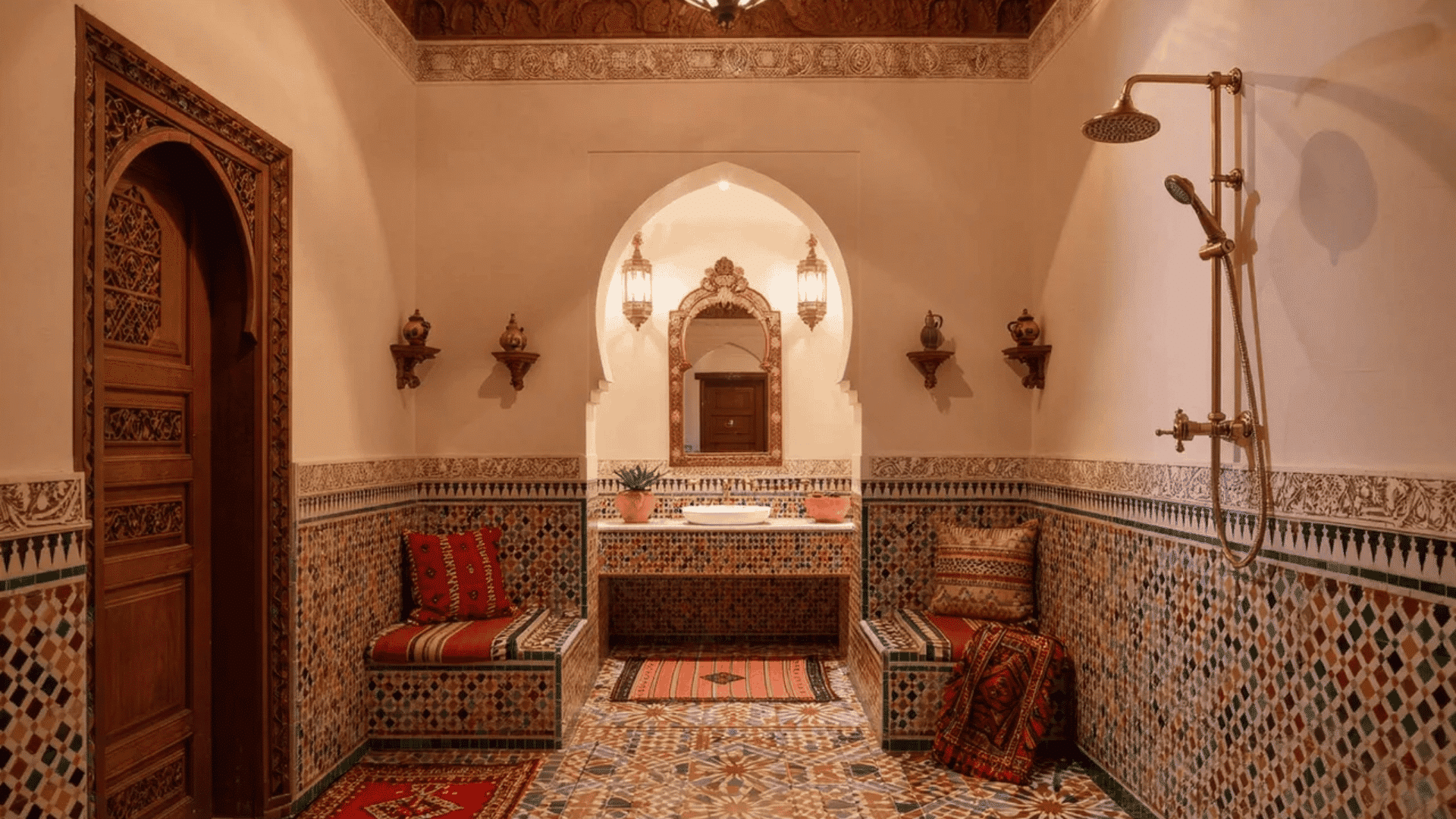 Moroccan interior design styles bathroom with mosaic tiles, arches, patterned walls, and wooden door.