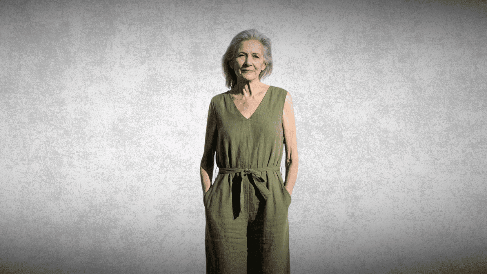 Older woman wearing a green boho jumpsuit with pockets indoors