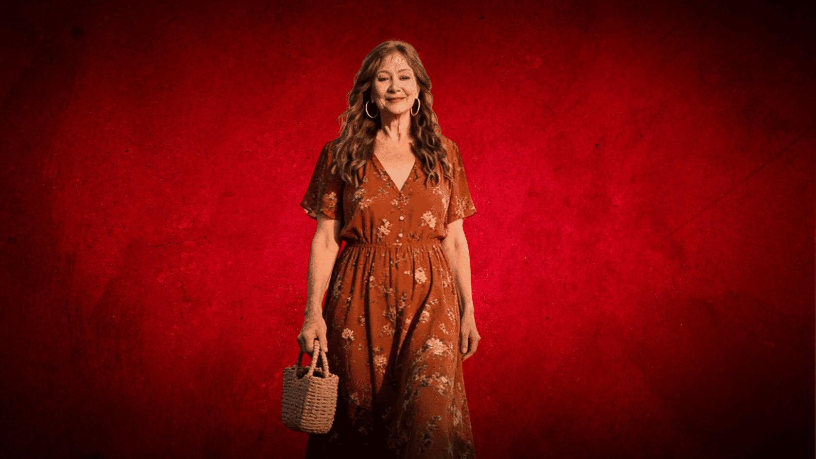 Older woman wearing a rust floral boho midi dress with a woven bag