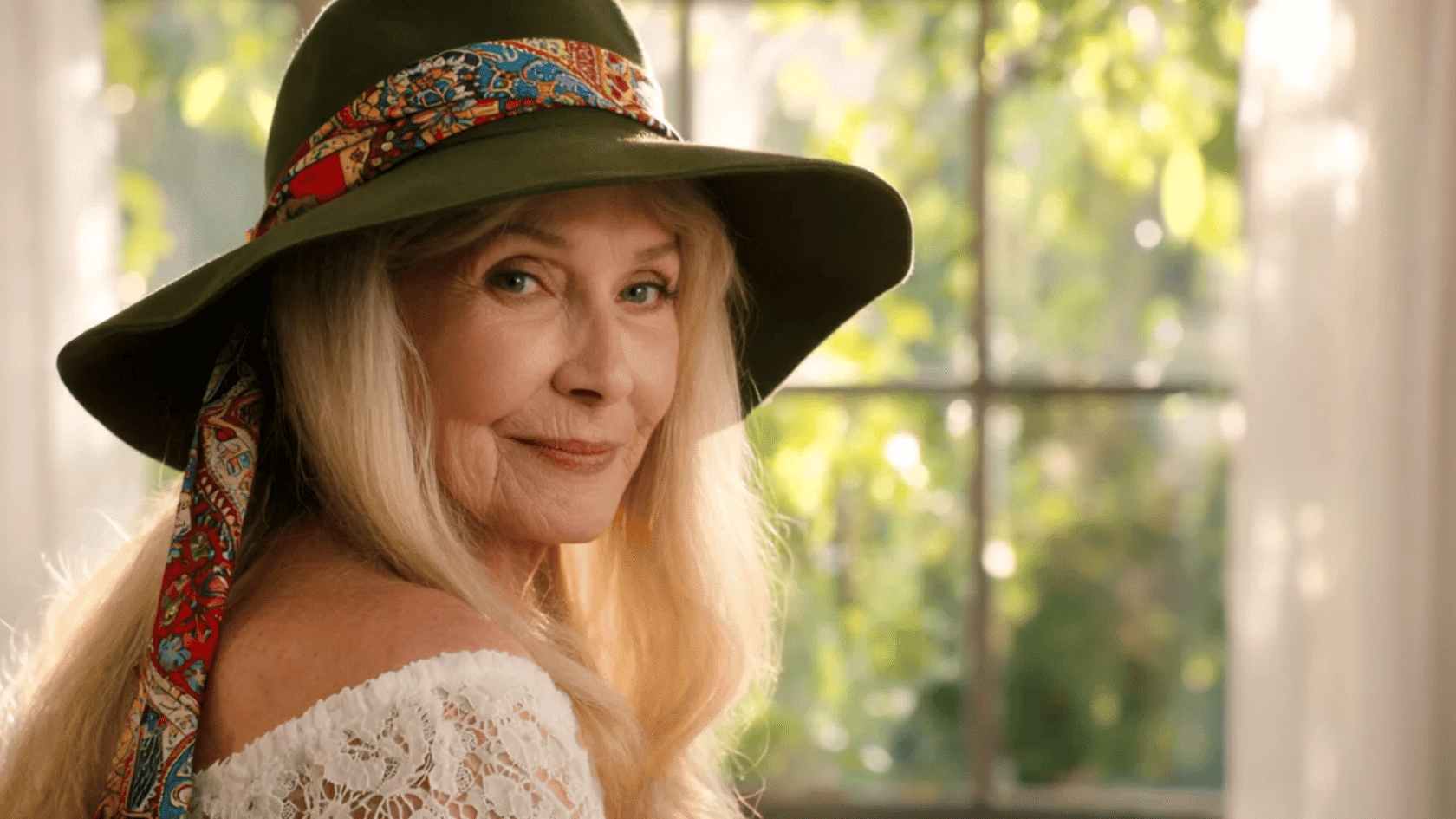 Older woman wearing a wide-brim boho hat with patterned band
