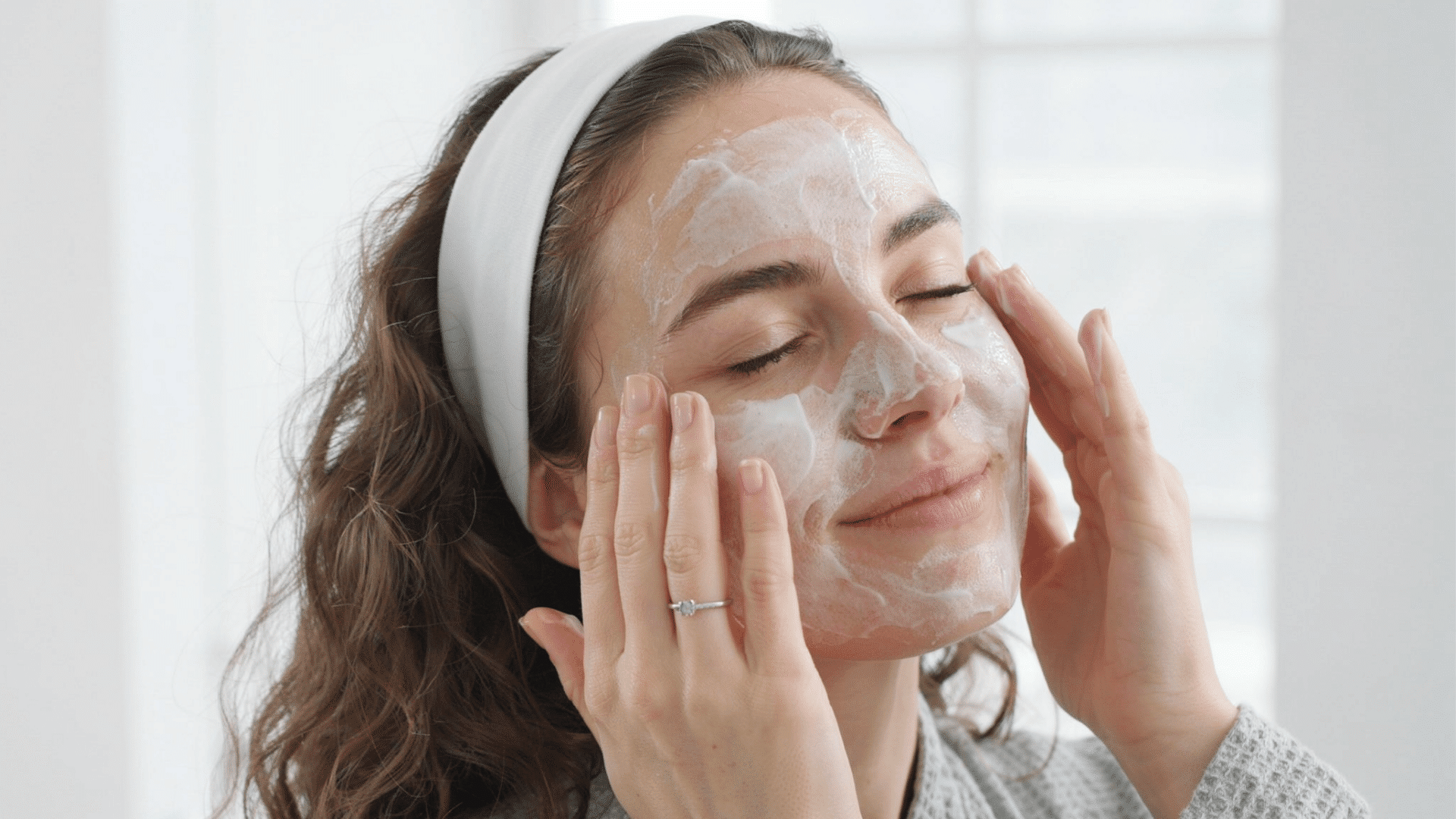 Person applying facial cleanser during a skincare routine for smoother skin