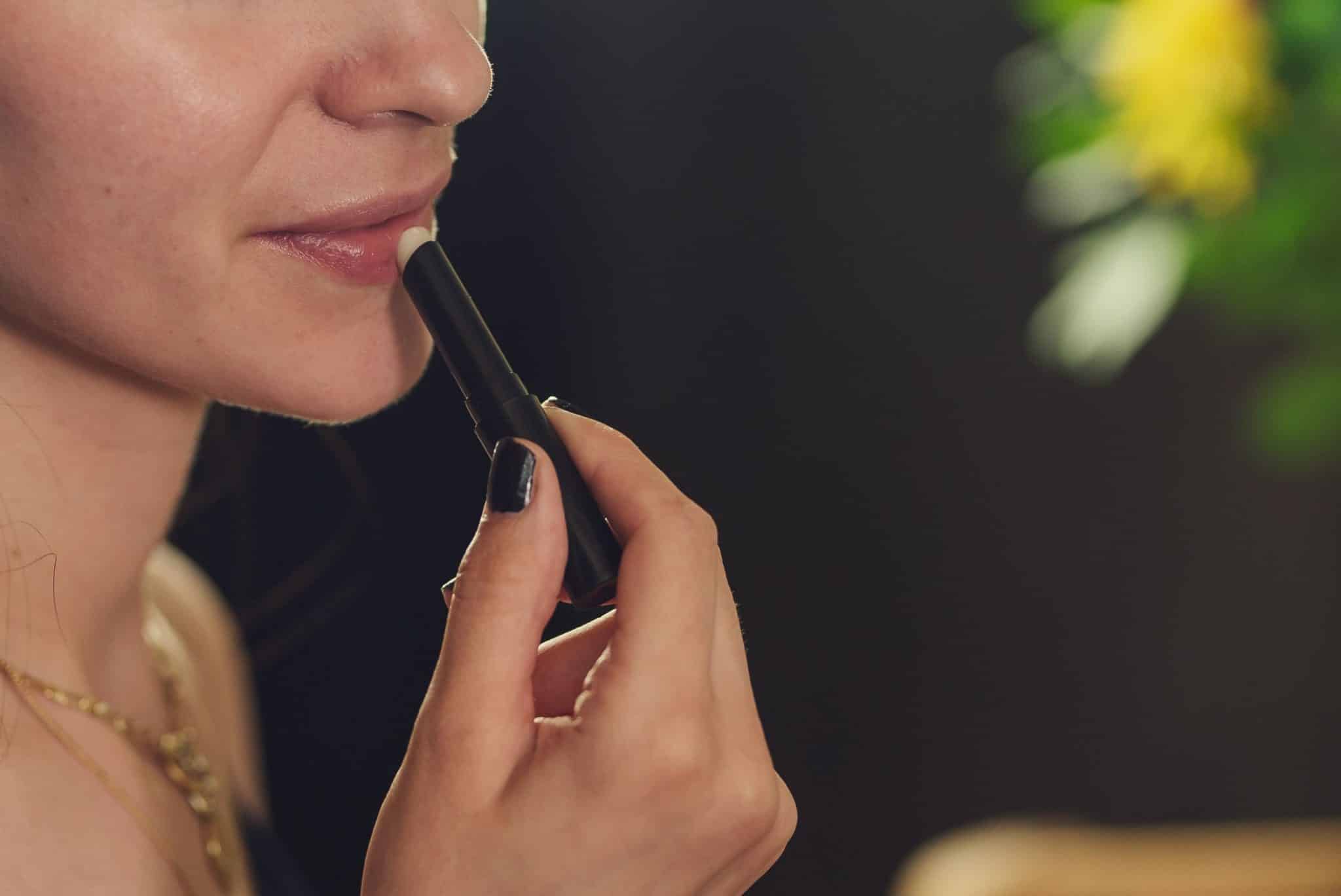 a lady applying lip balm