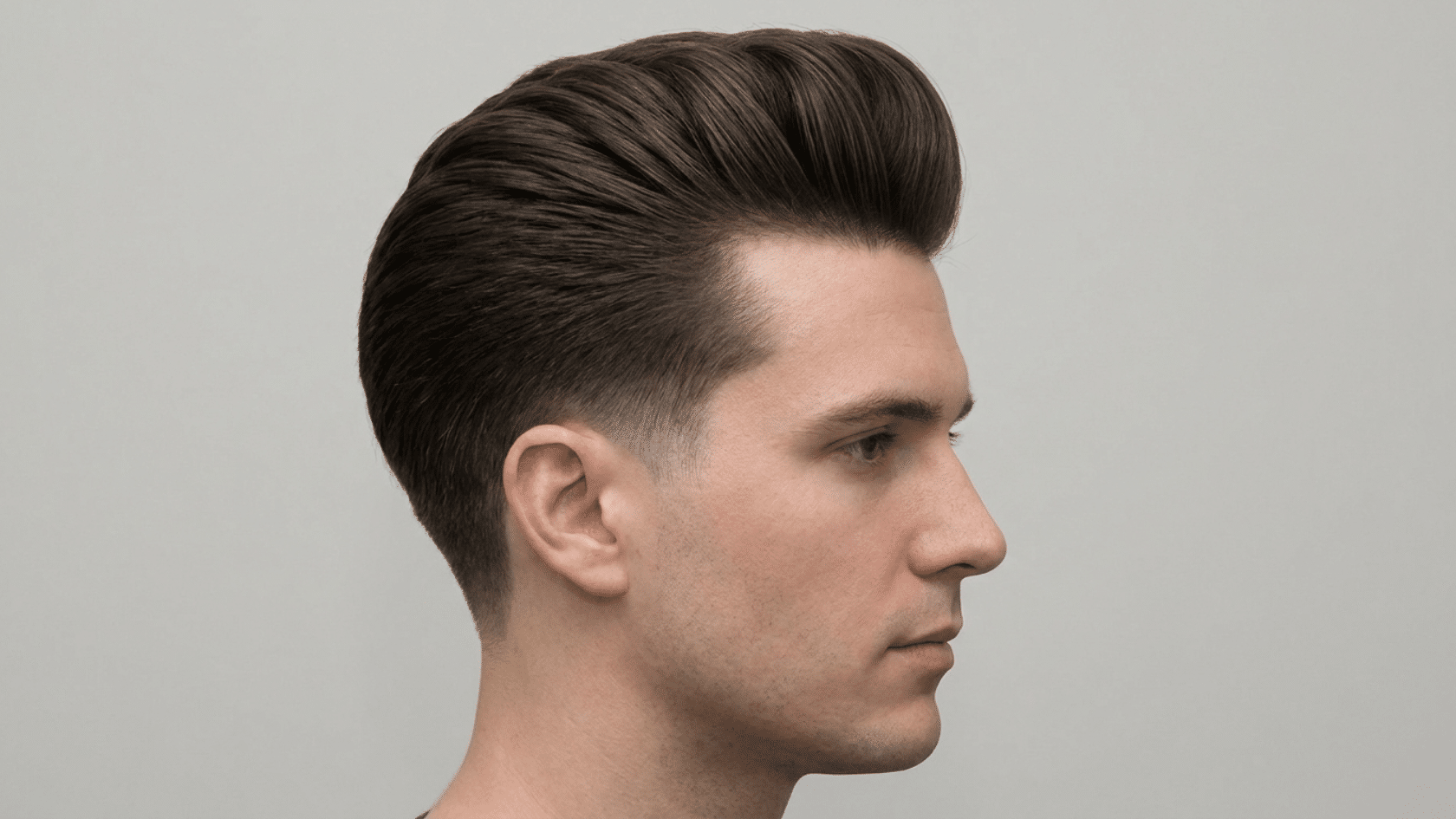Pompadour hairstyle for men with thinning hair showing smooth rounded swept-back mound above forehead with faded sides, side profile view.