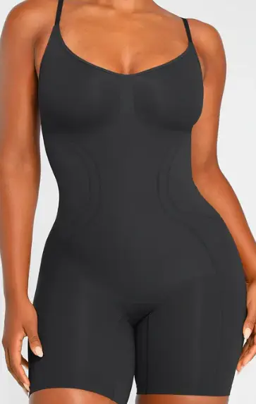 Black seamless shapewear bodysuit worn by model against plain background