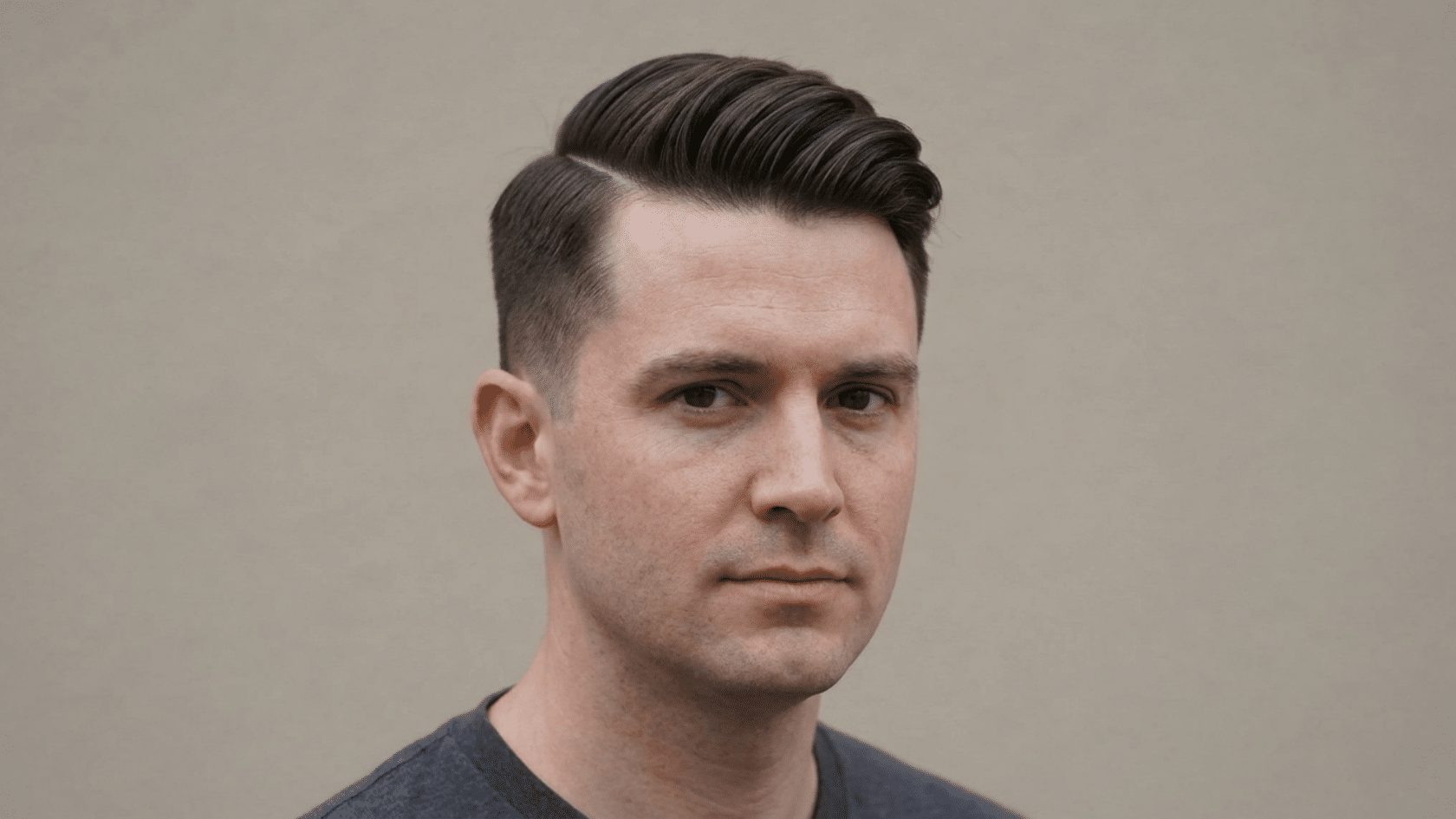 Side part hairstyle for men with thinning hair showing defined parting line with hair swept to one side and tapered sides, three-quarter view.