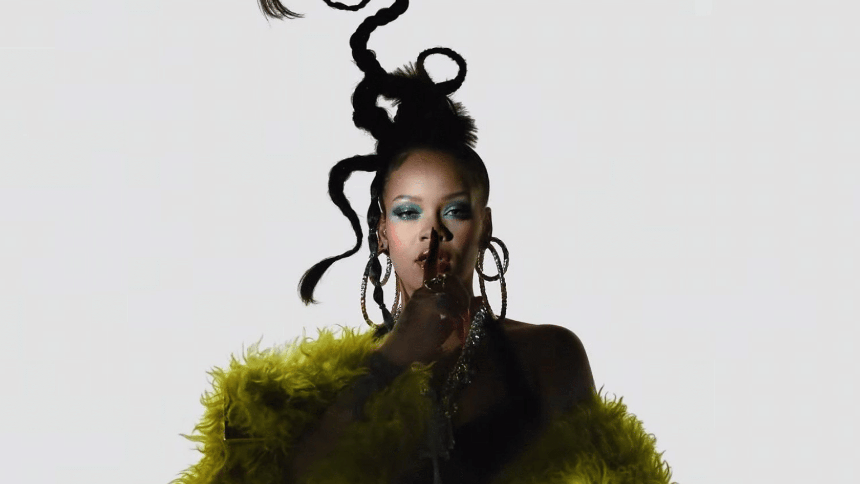 Woman in dramatic pose wearing a bright green fur coat with styled updo hair against a plain background.