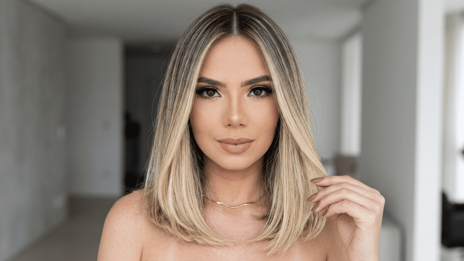 Woman with a collarbone-length haircut featuring straight, smooth hair with soft ends and a balanced, flattering shape.