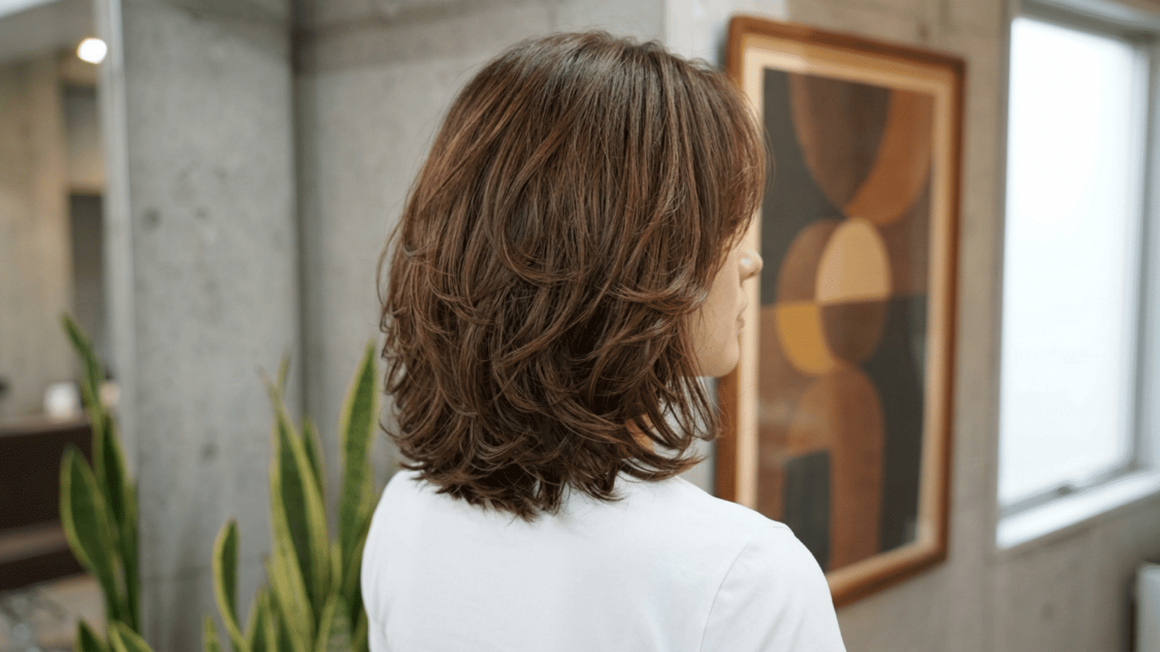 Woman with a layered shoulder-length haircut featuring soft layers, natural volume, and textured ends.