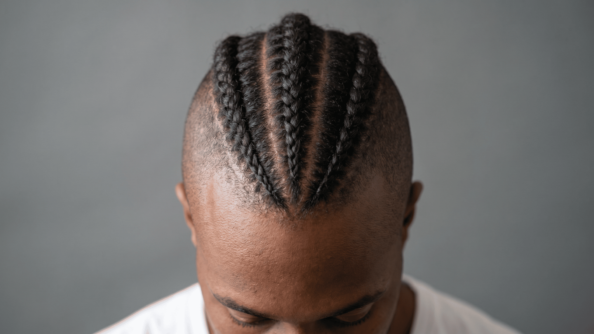 braided protective mohawk with cornrows forming a raised center, showing one of the types of mohawk styles