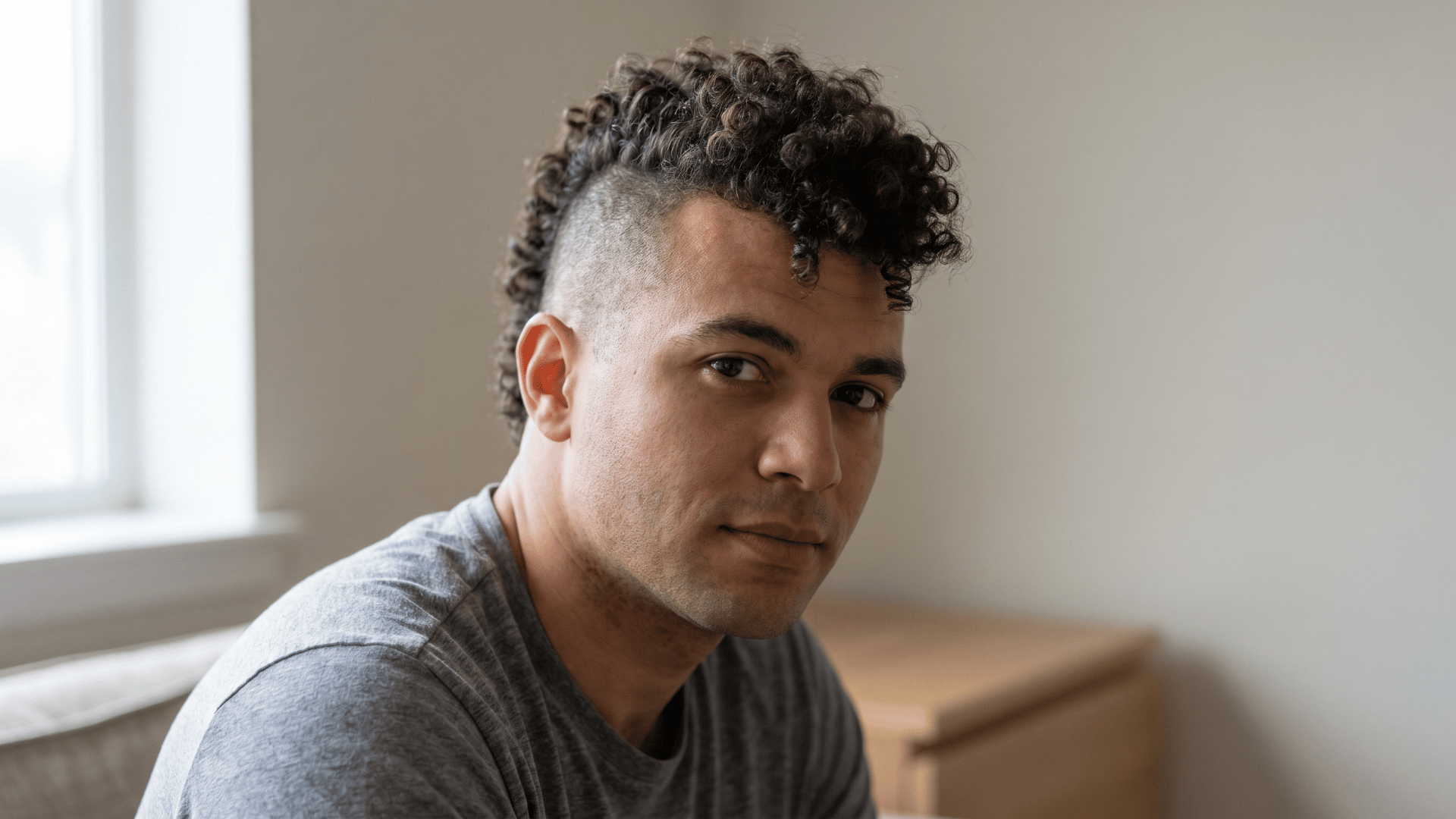 Curly mohawk fade with textured curls and faded sides showing one of the types of mohawks for men