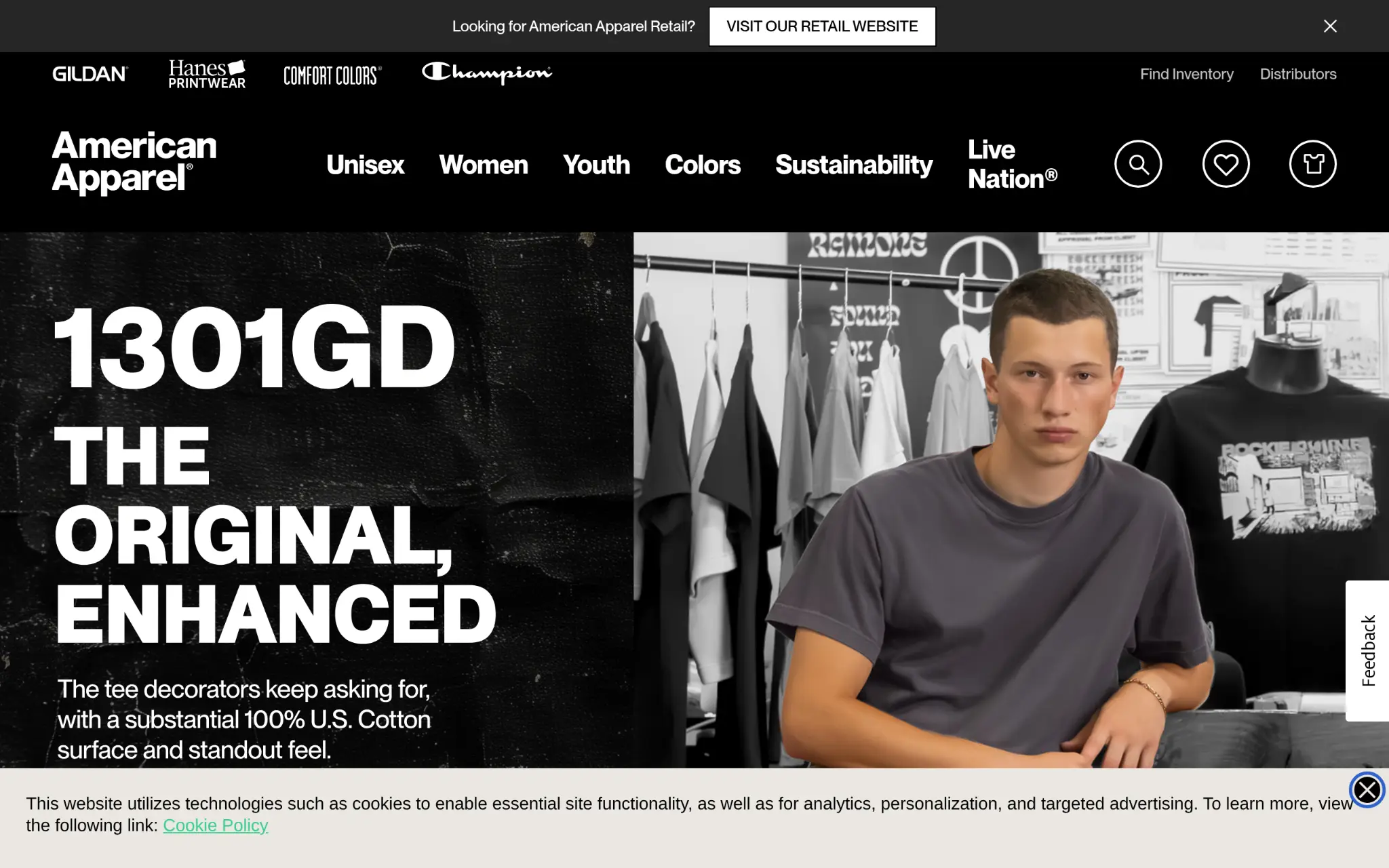 Man sitting in a clothing store, surrounded by hanging shirts and racks of apparel