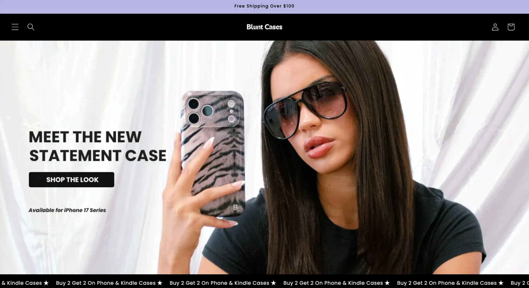Woman wearing sunglasses holding zebra print phone case against white curtain background