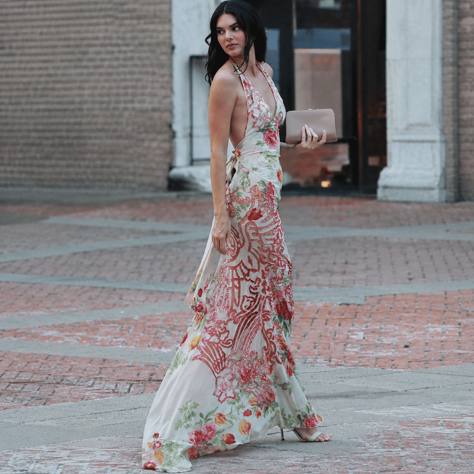 Kendall Jenner in a bold floral halter maxi dress showcasing elegant retro fashion trends on a city street.