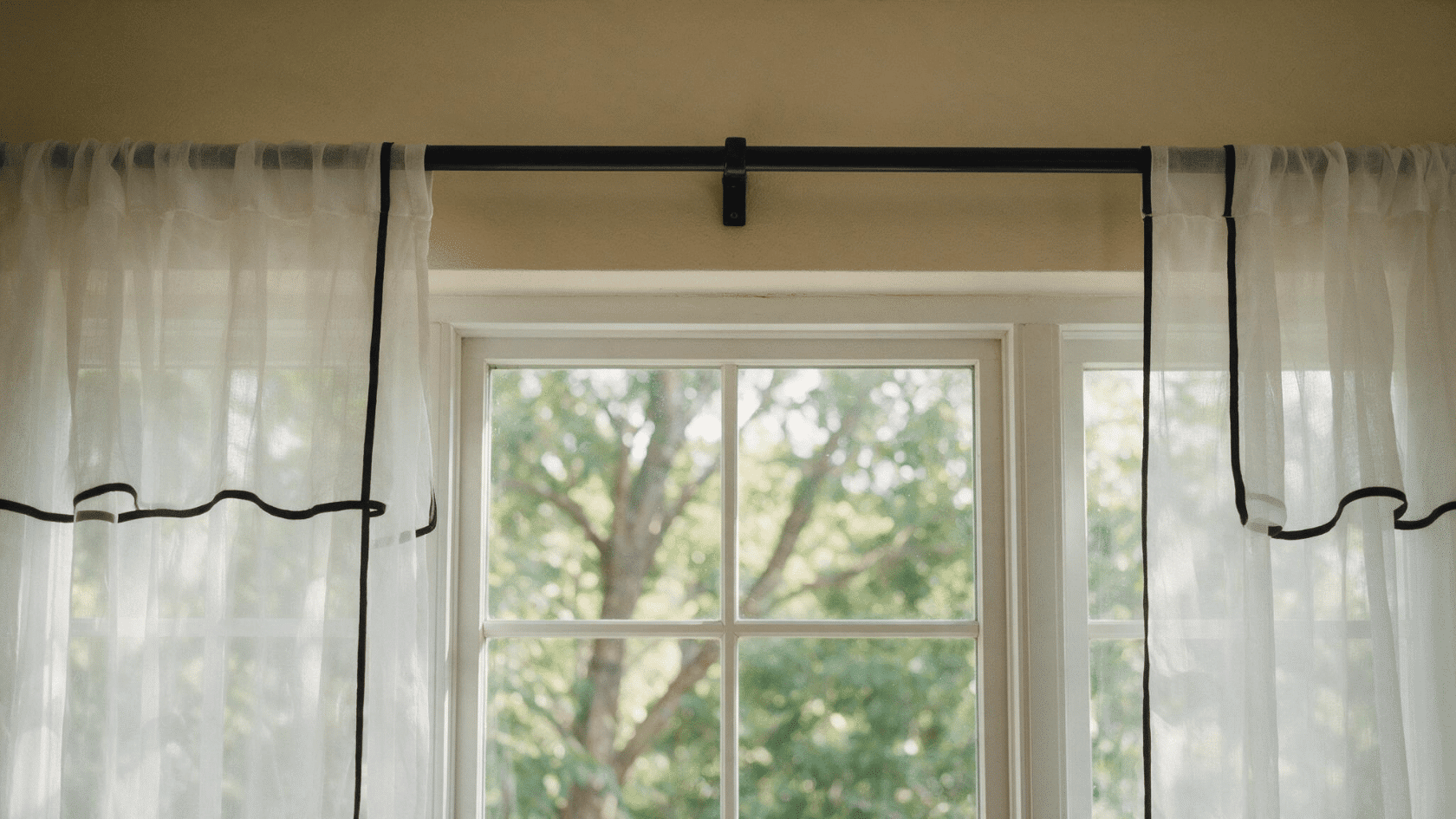 Hang curtains with Command Hooks using a curtain rod mounted above the window.