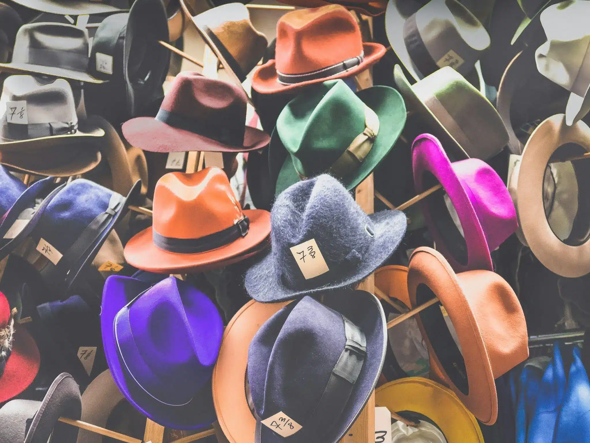 Colorful collection of vintage fedora hats on display in vibrant shop setting